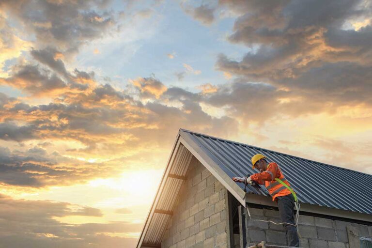 Roof replacement in progress above a home, with dry attic insulation and daylight visible through ventilation openings.